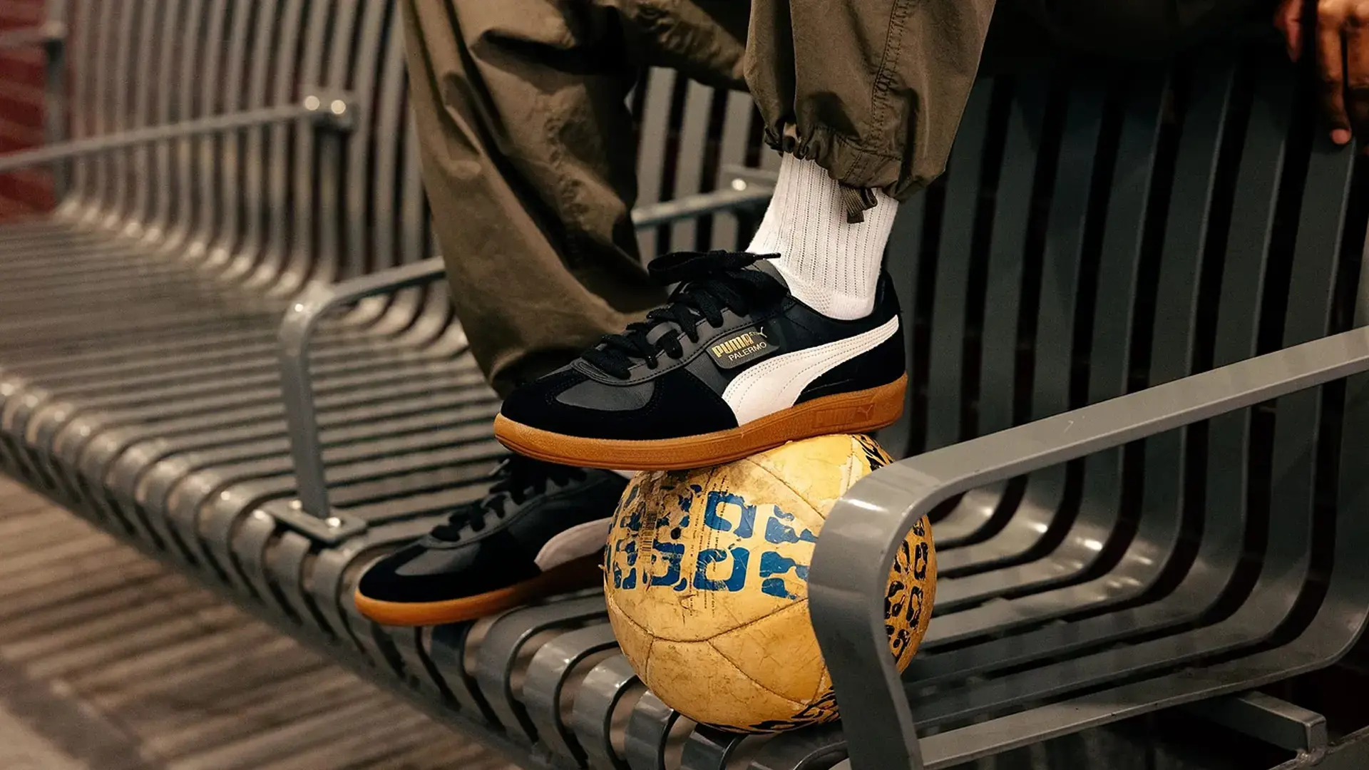 pies de hombre sobre un balon con tenis puma 